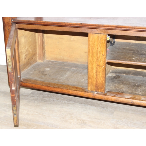 75 - An antique oak two tier buffet stand with cupboard base and carved frieze to top, late 19th or early... 