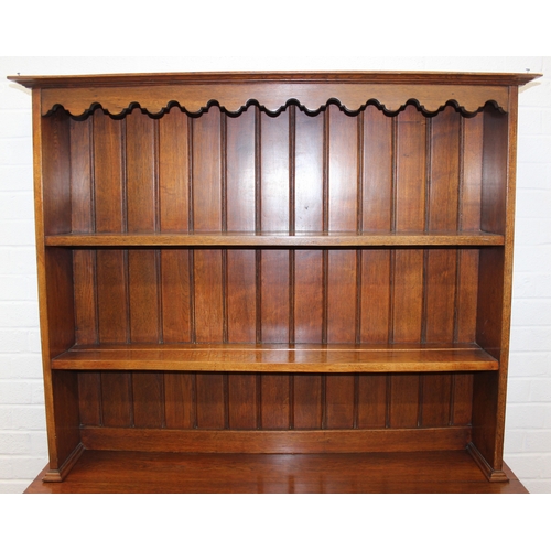 42 - An early 20th century oak two part dresser with cupboard base and open top, 122cm x 44cm x 185cm