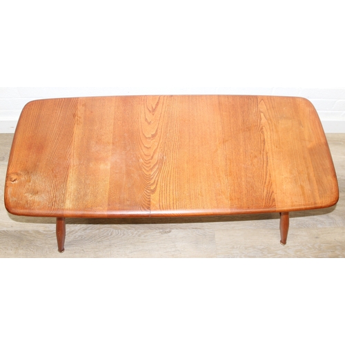 17 - A retro Ercol coffee table with magazine rack, golden dawn type finish, 104cm x 45cm x 37cm