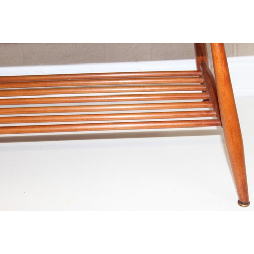 17 - A retro Ercol coffee table with magazine rack, golden dawn type finish, 104cm x 45cm x 37cm