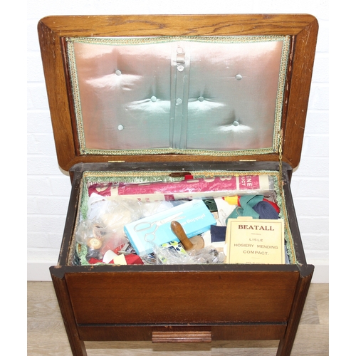 109 - A vintage oak sewing box on wheels with vintage contents inc cotton reels, 56cm x 37cm x 62cm