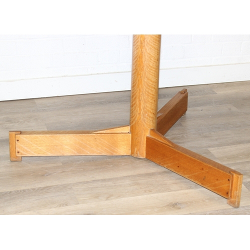 99 - A modern light oak dining table with pillar support and tripod base, 124cm in diameter x 71cm tall