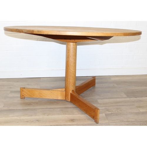 99 - A modern light oak dining table with pillar support and tripod base, 124cm in diameter x 71cm tall