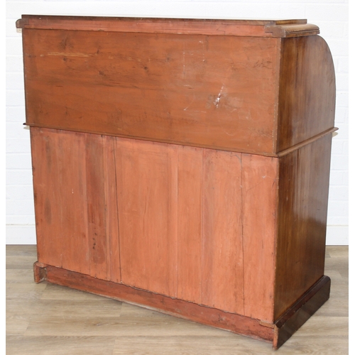 183 - A Victorian mahogany rolltop desk with fitted interior above a cupboard, plinth base, brass mounts, ... 