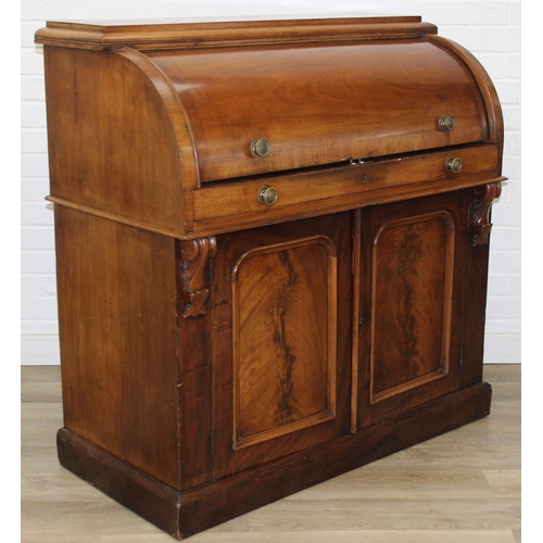 183 - A Victorian mahogany rolltop desk with fitted interior above a cupboard, plinth base, brass mounts, ... 