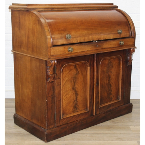 183 - A Victorian mahogany rolltop desk with fitted interior above a cupboard, plinth base, brass mounts, ... 