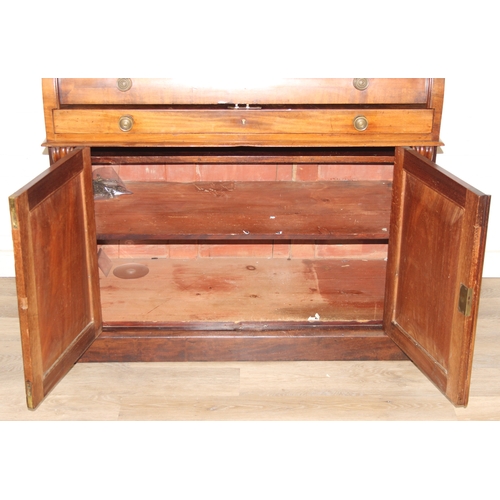183 - A Victorian mahogany rolltop desk with fitted interior above a cupboard, plinth base, brass mounts, ... 