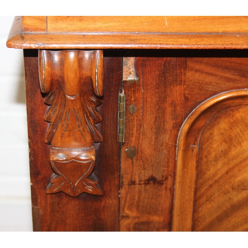 183 - A Victorian mahogany rolltop desk with fitted interior above a cupboard, plinth base, brass mounts, ... 
