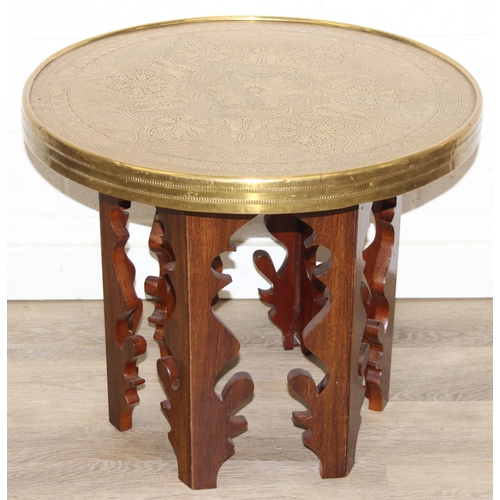 182 - A small vintage brass topped table with Moorish style carved wooden base, 60cm in diameter x 50cm ta... 