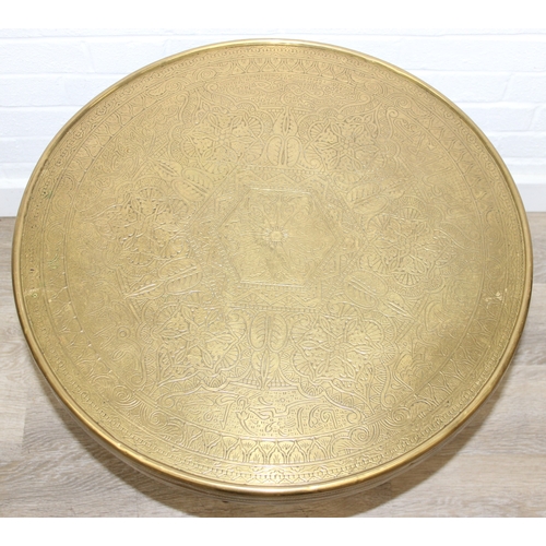 182 - A small vintage brass topped table with Moorish style carved wooden base, 60cm in diameter x 50cm ta... 