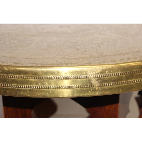 182 - A small vintage brass topped table with Moorish style carved wooden base, 60cm in diameter x 50cm ta... 