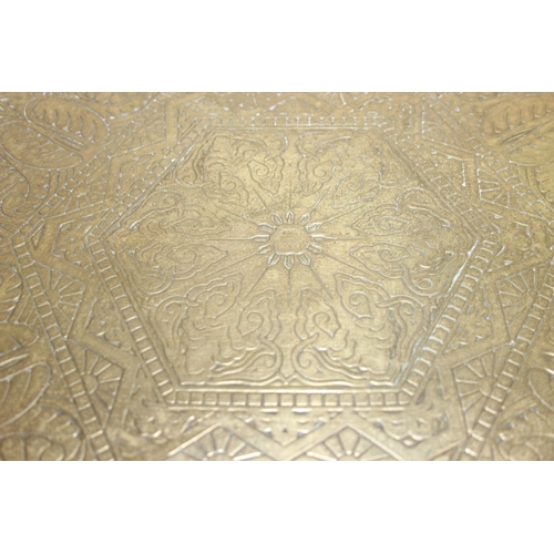 182 - A small vintage brass topped table with Moorish style carved wooden base, 60cm in diameter x 50cm ta... 