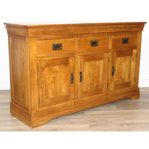 7 - A good quality modern light oak sideboard with three drawers over three cupboards, bronzed metal fit... 