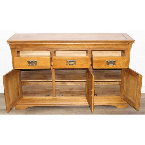 7 - A good quality modern light oak sideboard with three drawers over three cupboards, bronzed metal fit... 