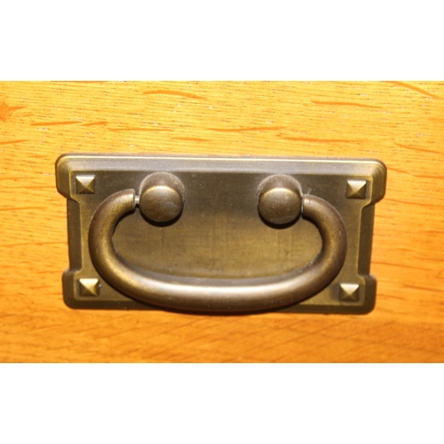 7 - A good quality modern light oak sideboard with three drawers over three cupboards, bronzed metal fit... 