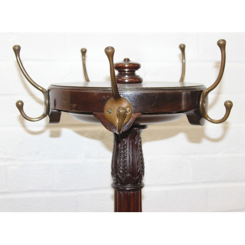 65 - An antique mahogany coat stand with reeded pillar and carved with wheat sheaths, five brass hooks an... 