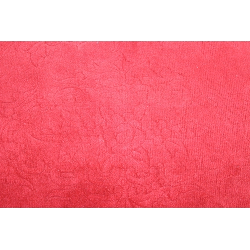 210 - A red ground rug with floral decoration, one of two in the sale, 209cm x 94cm