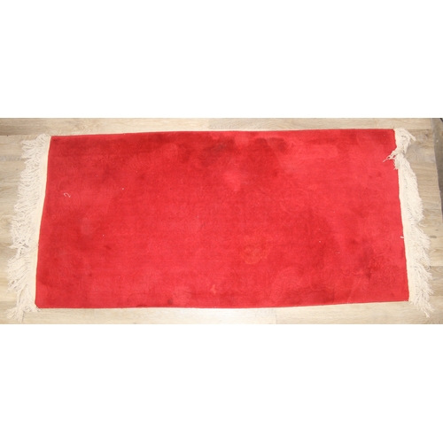 210A - A red ground rug with floral decoration, one of two in the sale, 209cm x 94cm