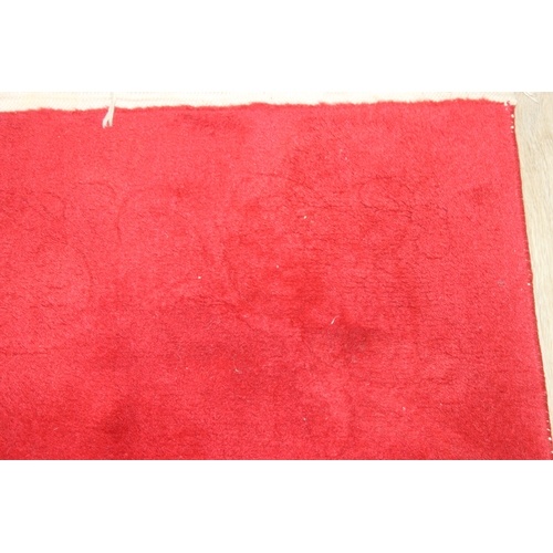 210A - A red ground rug with floral decoration, one of two in the sale, 209cm x 94cm