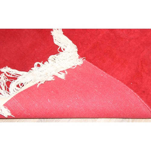 210A - A red ground rug with floral decoration, one of two in the sale, 209cm x 94cm