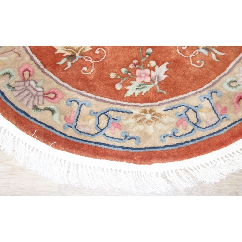 211 - Two circular Chinese wool rugs, one salmon ground, the other russet, each 140cm in diameter [2]