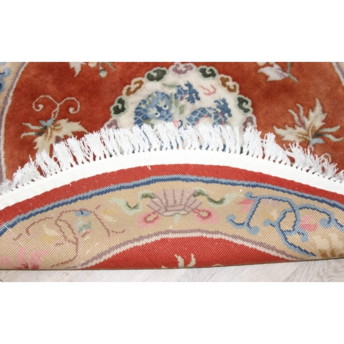 211 - Two circular Chinese wool rugs, one salmon ground, the other russet, each 140cm in diameter [2]