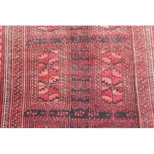 213 - A vintage Turkoman rug of red ground, 155cm x 105cm