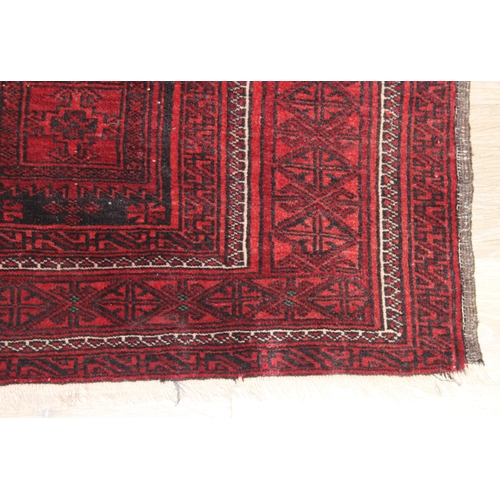 213 - A vintage Turkoman rug of red ground, 155cm x 105cm