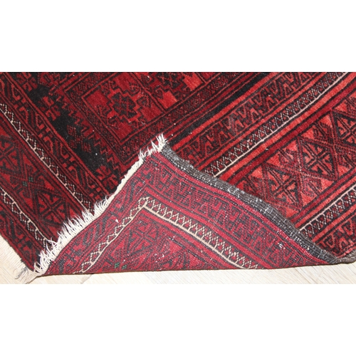 213 - A vintage Turkoman rug of red ground, 155cm x 105cm