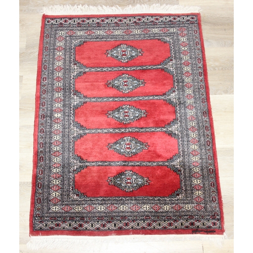 214 - A red ground Uzbek style Bukhara rug, made in Pakistan, 138cm x 94cm