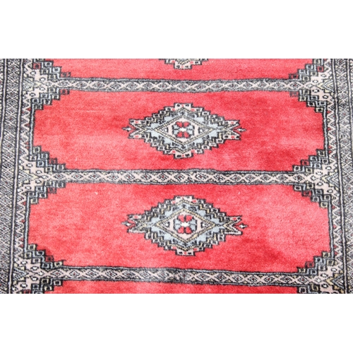 214 - A red ground Uzbek style Bukhara rug, made in Pakistan, 138cm x 94cm
