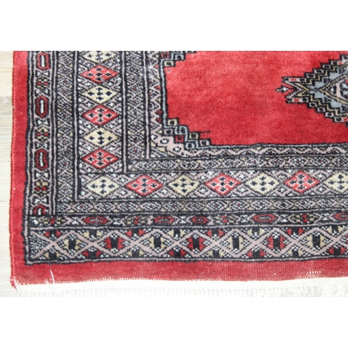 214 - A red ground Uzbek style Bukhara rug, made in Pakistan, 138cm x 94cm