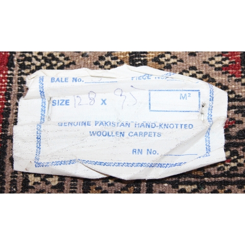 214 - A red ground Uzbek style Bukhara rug, made in Pakistan, 138cm x 94cm