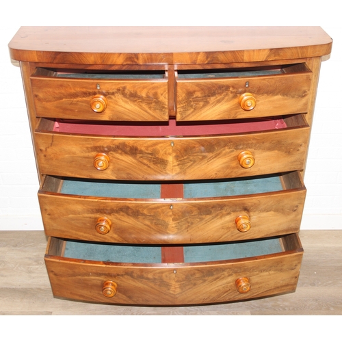 181 - A Victorian flame mahogany bow fronted two over three chest of drawers with bun handles and turned f... 