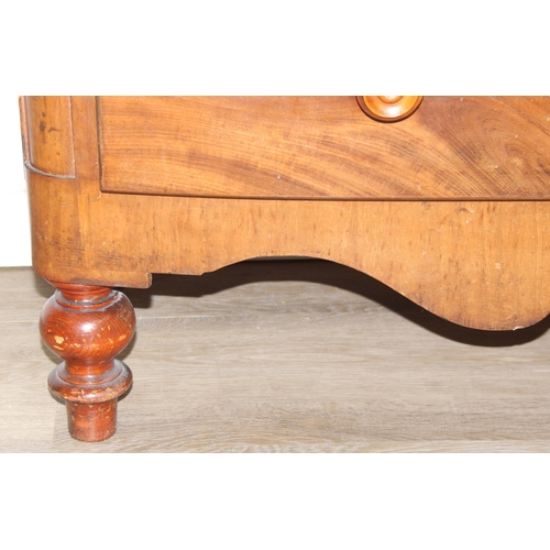 181 - A Victorian flame mahogany bow fronted two over three chest of drawers with bun handles and turned f... 