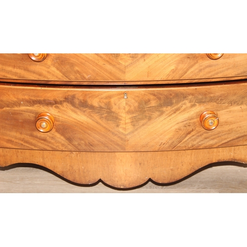 181 - A Victorian flame mahogany bow fronted two over three chest of drawers with bun handles and turned f... 