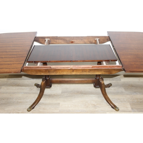 89 - A Georgian style mahogany dining table with brass paw feet and a set of six matching dining chairs, ... 