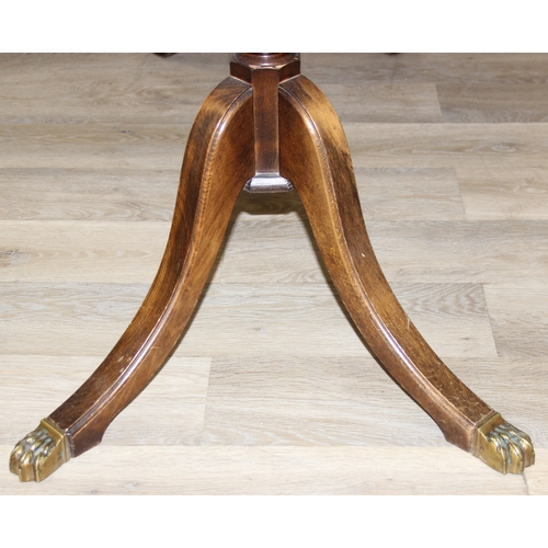89 - A Georgian style mahogany dining table with brass paw feet and a set of six matching dining chairs, ... 