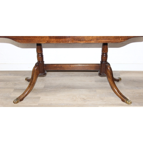 89 - A Georgian style mahogany dining table with brass paw feet and a set of six matching dining chairs, ... 