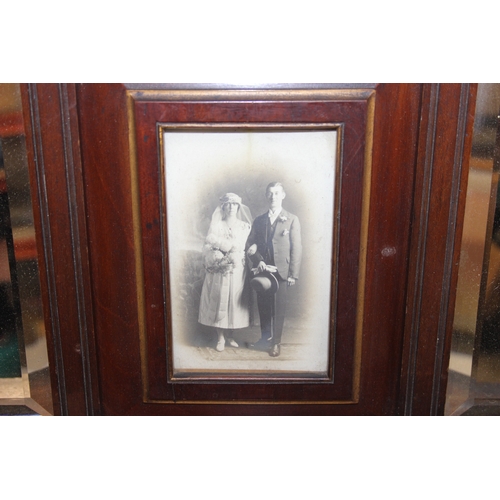 286 - An antique Edwardian mahogany wall shelf with bevelled-edged mirror, display shelf and central photo... 
