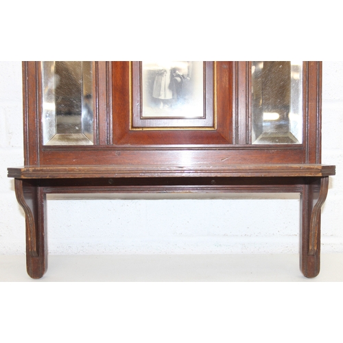 286 - An antique Edwardian mahogany wall shelf with bevelled-edged mirror, display shelf and central photo... 