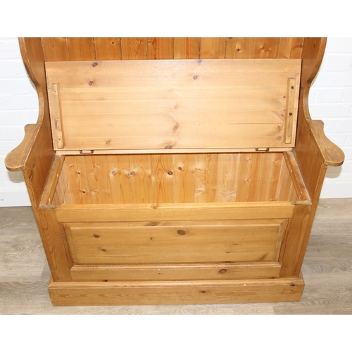 55 - A vintage pine settle or hall seat with storage box seat, carved details, 91cm x 43cm x 109cm