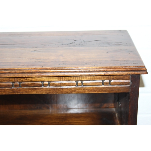 189 - A vintage bookcase with three shelves and panelled sides, unknown wood with prominent grain, possibl... 