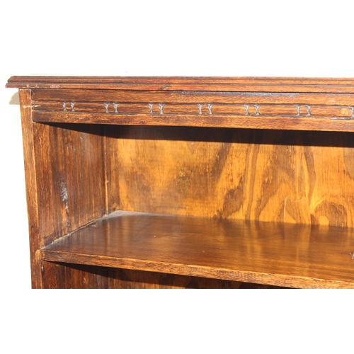 189 - A vintage bookcase with three shelves and panelled sides, unknown wood with prominent grain, possibl... 