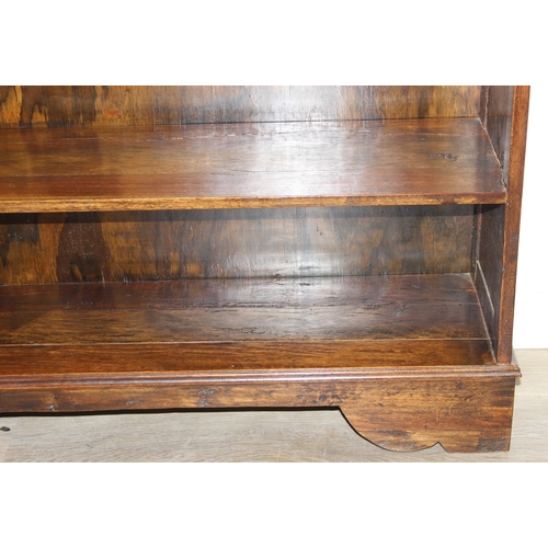 189 - A vintage bookcase with three shelves and panelled sides, unknown wood with prominent grain, possibl... 