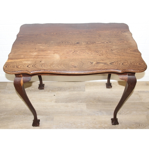 64 - A small wooden table with wavy edge and ball and claw feet, unknown wood with prominent grain, possi... 