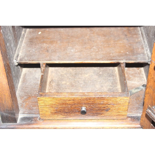 63 - A vintage oak cabinet with fitted interior for holding smoking pipes and a vintage wooden magazine r... 