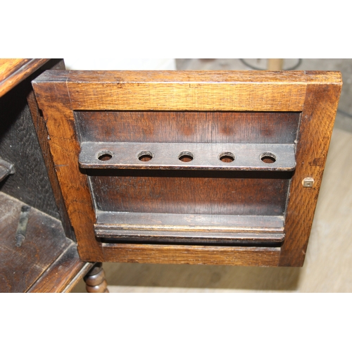 63 - A vintage oak cabinet with fitted interior for holding smoking pipes and a vintage wooden magazine r... 