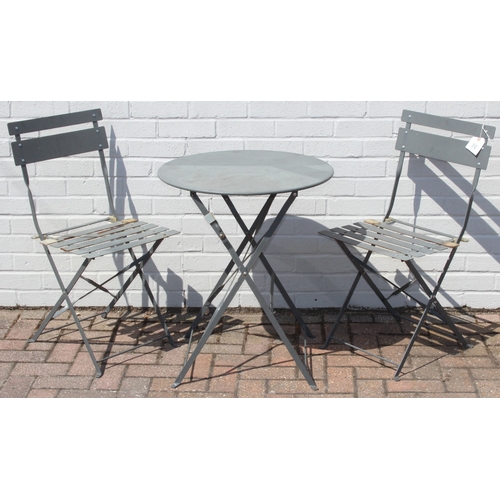 312 - A folding metal bistro table and two folding chairs, the table 60cm in diameter
