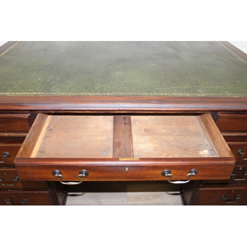 186 - A vintage mahogany partner's three-part pedestal desk with inset green leather top, eighteen drawers... 